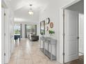 Bright and airy foyer featuring tile flooring, a decorative console table, and an open view into the living areas at 369 Ocean Course Ave, Davenport, FL 33896