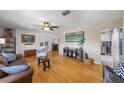 Open living space with hardwood floors, a ceiling fan, and seamless flow into the adjacent dining and kitchen areas at 3722 Neptune Dr, Orlando, FL 32804