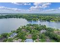 Gorgeous aerial view of a lakeside home surrounded by lush greenery and beautiful waterfront scenery at 446 Alberta Dr, Winter Park, FL 32789