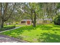 Beautiful single-story home with a lush green lawn, mature trees, and nice curb appeal at 446 Alberta Dr, Winter Park, FL 32789