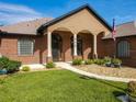 Welcoming front entrance with arched columns, brick facade, landscaped garden, and a well-manicured lawn at 448 Warrior Trl, Deltona, FL 32725