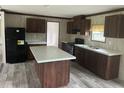 Spacious kitchen features dark cabinetry, a central island, and modern black appliances at 45814 Lake St, Paisley, FL 32767