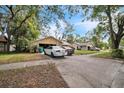 View of the house exterior showing the driveway and front yard with mature trees at 4799 Lighthouse Rd, Orlando, FL 32808