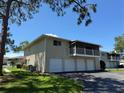 Low-angle exterior view showing the condo's multiple garages and balcony on a sunny day at 5564 Slash Pine Ct # 4, Orlando, FL 32811