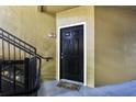 Apartment front door with black trim and a 'Welcome' mat near stairs with black metal handrails at 6029 Westgate Dr # 726, Orlando, FL 32835