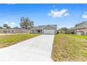A single-story home with a long concrete driveway, two-car garage, and fresh landscaping in the front yard at 654 Ne 130Th Ct, Silver Springs, FL 34488