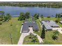 Aerial view of waterfront home featuring lush landscaping, swimming pool, and private dock at 6790 Bay Shore Dr, St Cloud, FL 34771