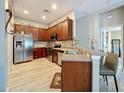 Well-equipped kitchen with stainless steel appliances, wood cabinets, and a breakfast bar with seating at 725 Ashworth Overlook Dr # C, Apopka, FL 32712