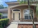 Inviting home entrance featuring sidelights, decorative brick accents, and tidy landscaping at 8012 Old Town Dr, Orlando, FL 32819
