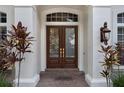 Close-up of a sophisticated entryway with a double glass front door and sidelights at 9142 Southern Breeze Dr, Orlando, FL 32836