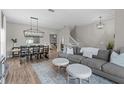 Open-concept living room featuring hardwood floors, a stylish sofa, and plenty of natural light at 9319 Marsh Oaks Ct, Orlando, FL 32832