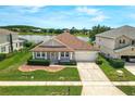 Beautiful single-story home with a well-manicured lawn, landscaping, and a scenic lake view at 10151 Chorlton Cir, Orlando, FL 32832