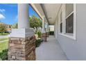 Inviting covered front porch featuring substantial stone support columns and a smooth concrete floor at 10151 Chorlton Cir, Orlando, FL 32832