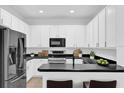 Modern kitchen features sleek white cabinets, stainless steel appliances, and a dark countertop at 1122 Sandstone Run, Sanford, FL 32771