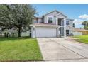 Charming two-story home featuring an attached garage and manicured lawn at 12643 Lakebrook Dr, Orlando, FL 32828