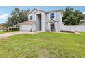 Charming two-story home featuring an attached garage and manicured lawn at 12643 Lakebrook Dr, Orlando, FL 32828