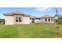 Low-angle view of house featuring a well-kept lawn and stone accents at 13023 Sweet Hill Rd, Polk City, FL 33868