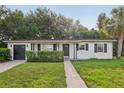 Delightful home featuring black accents, an attached garage, and a well-maintained lawn, providing classic charm at 1320 E Lombardy Dr, Deltona, FL 32725