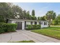Inviting home showcases manicured hedges, a driveway, and an attached garage, offering both curb appeal and convenience at 1320 E Lombardy Dr, Deltona, FL 32725