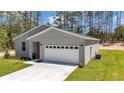 Charming single-story home with gray siding, a two-car garage, and a well-maintained lawn with an A/C unit at 13264 Sw 69Th Pl, Ocala, FL 34481