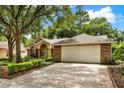 Traditional brick home featuring a two-car garage and manicured landscaping, providing a classic aesthetic at 1453 Maple Leaf Ln, Deland, FL 32724