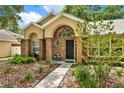Inviting front entrance with brick archway and complemented by lush landscaping for an appealing facade at 1453 Maple Leaf Ln, Deland, FL 32724