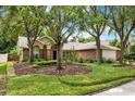 Beautiful brick home with a neatly landscaped front yard and mature trees, offering a welcoming entrance at 1453 Maple Leaf Ln, Deland, FL 32724