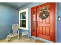 Inviting front entrance with a red door, wreath, and a cozy seating area for welcoming guests at 171 Cedarpark Ln, Davenport, FL 33837