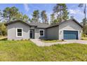 Well-kept single-story home featuring a blue garage door and a lush green front lawn at 17445 Sw 41St Cir, Ocala, FL 34473