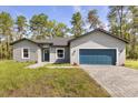 Charming single-story home featuring a blue garage door and well-maintained front yard at 17445 Sw 41St Cir, Ocala, FL 34473
