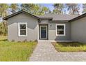 Inviting home facade with a paved walkway leading to a blue front door at 17445 Sw 41St Cir, Ocala, FL 34473