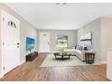 Bright living room with light walls, vinyl floors, and a large window overlooking the yard at 214 S Cottage Hill Rd, Orlando, FL 32805