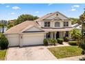 Spacious two-story home with a three-car garage, landscaped front yard, and inviting entryway at 2512 Chapala Dr, Kissimmee, FL 34746