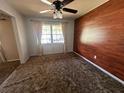Comfortable bedroom with lots of natural light, wood accent wall, and neutral decor at 3540 Garland St, Mulberry, FL 33860