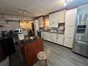 Bright kitchen with granite countertops, stainless steel refrigerator, and modern white cabinets at 3540 Garland St, Mulberry, FL 33860
