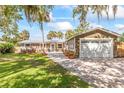 Charming single-story home with a paver driveway, attached garage, lush landscaping and beautiful curb appeal at 418 Acacia Cir, Port Orange, FL 32127