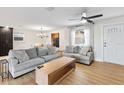 Bright living room with cozy seating, light wood floors, a ceiling fan and view into the dining room at 418 Acacia Cir, Port Orange, FL 32127