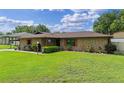Traditional brick home boasts a lush green lawn with mature landscaping and a cozy, welcoming facade at 51 Seminole Dr, Debary, FL 32713