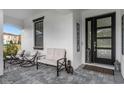 Charming front porch featuring comfortable seating, stylish decor, and a welcoming entrance with modern door at 7454 Gathering Dr, Reunion, FL 34747