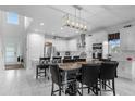 Bright kitchen with white cabinets, stainless steel appliances, kitchen island, and adjacent dining area at 7454 Gathering Dr, Reunion, FL 34747