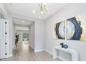 Inviting foyer with neutral walls, wood-look tile flooring, modern chandelier, and stylish decor, creates a bright and welcoming space at 977 Talon Pl, Winter Springs, FL 32708