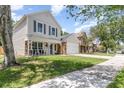Two-story home with neutral siding, stone accents, covered porch, and a well-kept lawn at 1033 Mccully Ct, Oviedo, FL 32765