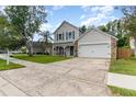 Two-story home with neutral siding, stone accents, a covered porch, and a driveway at 1033 Mccully Ct, Oviedo, FL 32765