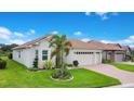 Charming single-story home with well-manicured lawn and a three-car garage at 1104 Sawgrass Dr, Winter Haven, FL 33884