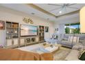 Spacious living room featuring a large sectional, built-in shelving, and a modern ceiling fan at 1104 Sawgrass Dr, Winter Haven, FL 33884
