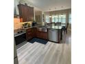 Modern kitchen with stainless steel appliances, granite countertops, an island, and ample natural light from the windows at 1165 Baltic Ln, Winter Springs, FL 32708