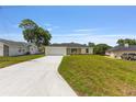 A single-story home with a large front lawn and long concrete driveway offers ample parking space at 13031 Ne 7Th Loop, Silver Springs, FL 34488