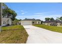 A single-story home with a large front lawn and long concrete driveway offers ample parking space at 13031 Ne 7Th Loop, Silver Springs, FL 34488