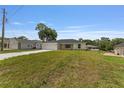 A single-story home with a large front lawn and long concrete driveway offers ample parking space at 13031 Ne 7Th Loop, Silver Springs, FL 34488