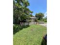 Quaint single-story home surrounded by mature trees and a charming white picket fence at 1307 Mabbette St, Kissimmee, FL 34741